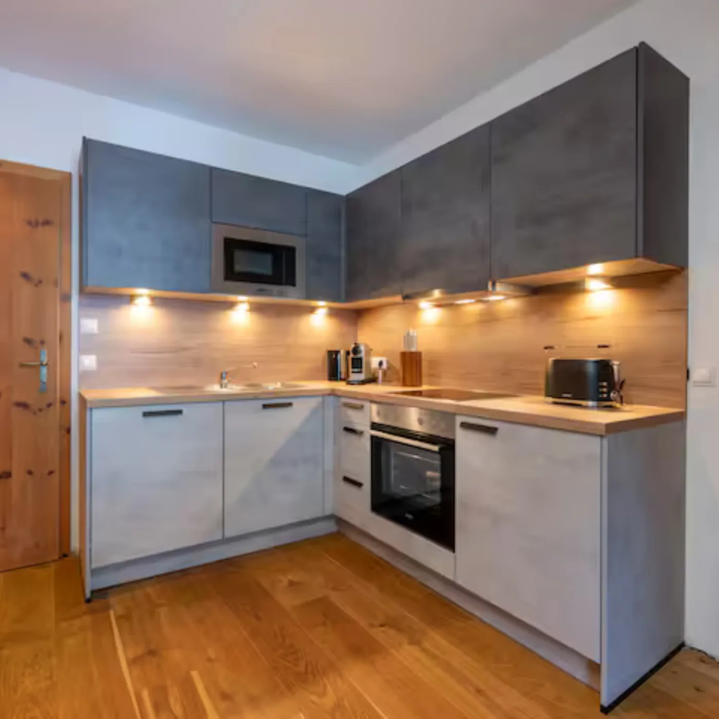 Küchenzeile über Eck mit Induktionskochfeld, Backofen, Mikrowelle, Toaster und Kaffeemaschine